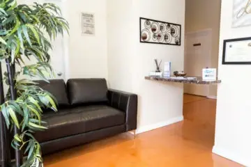 Welcoming reception area at Seacrest Recovery Center NJ with leather couch, plants, and front desk in Eatontown.